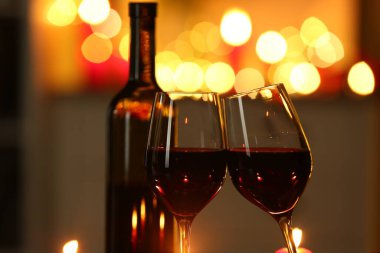 Bulanık ışıklara karşı kırmızı şarap kadehleri, yakın plan. Romantik yemek.