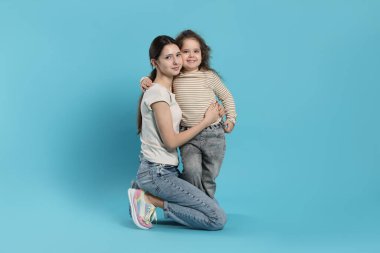 Açık mavi arkaplanda güzel kız kardeşlerin portresi