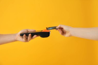 Sarı arkaplan üzerinden müşteriden ödeme alan adam, yakın plan