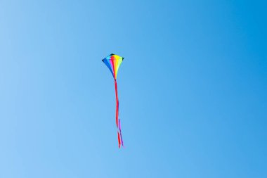 Mavi gökyüzünde uçan renkli bir uçurtma