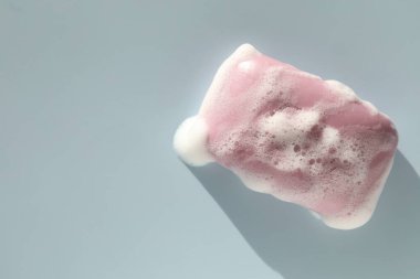 Gri mavi arka planda köpüklü sabun çubuğu, üst manzara. Metin için boşluk