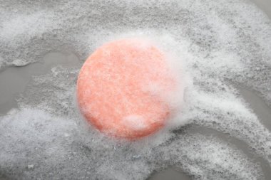 Gri arka planda köpük olan sabun çubuğu, üst görünüm