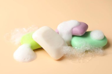 Bej arkaplanda köpük olan sabun çubukları