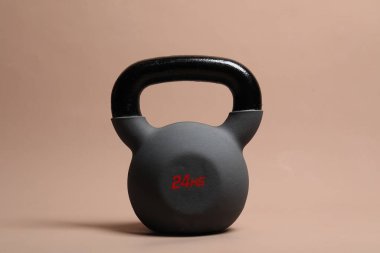 Bej arka planda ağır bir kettlebell. Spor malzemeleri.
