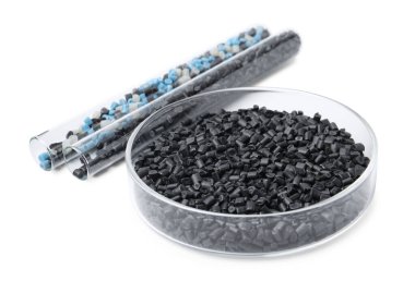 Petri kabında renkli plastik granüller ve beyaz üzerinde izole edilmiş test tüpleri.