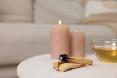 Palo santo çubukları, yanan mumlar ve çay beyaz masa içinde, mesaj için yer