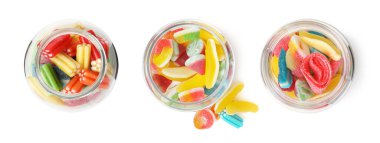 Cam kavanozlardaki farklı parlak şekerler beyaz, üstten görünüyor.