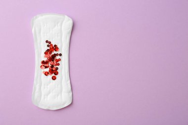 Leylak arkaplanda pulları olan regl yastığı, üst manzara. Metin için boşluk