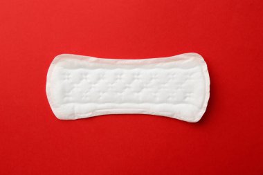 Kırmızı arkaplanda regl pedi, üst görünüm