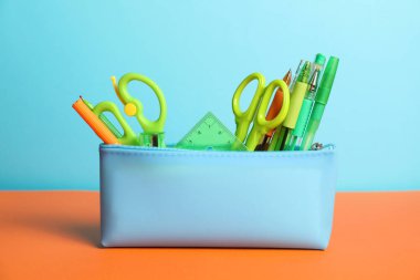 Renk arkaplanındaki kalem kutusunda farklı kırtasiye