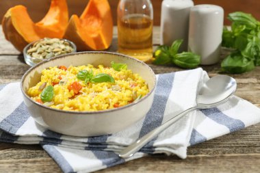 Ahşap masada servis edilen lezzetli balkabaklı risotto, yakın plan.