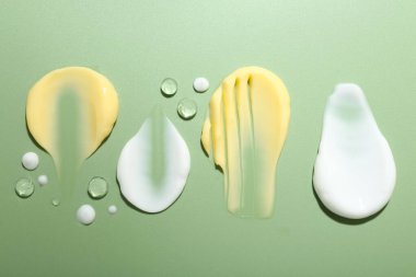 Açık yeşil zemin üzerinde krem ve jel örnekleri düz yatıyordu