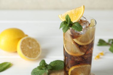 Limon dilimli taze buzlu kola ve beyaz ahşap masada nane şekeri. Yakın plan.