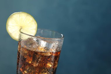 Mavi arka planda limon dilimli buzlu kola, yakın plan. Metin için boşluk