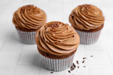 Beyaz fayanslı masada çikolatalı kremalı lezzetli kekler, yakın plan.