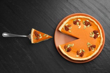 Lezzetli ev yapımı balkabağı turtası ve sunucu siyah masada.