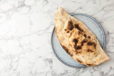 Beyaz mermer masada nefis bir calzone, üst manzara. Metin için boşluk