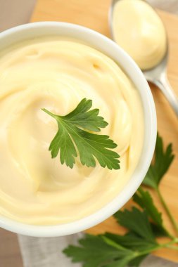 Maydanozlu mayonez sosu ve masada kaşık ve mayonez.