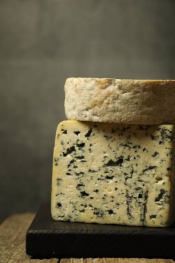 Taze peynir ahşap masada, gri arka planda, yakın plan.