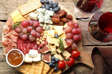 Farklı lezzetli peynir çeşitleri, diğer atıştırmalıklar ve şarap ahşap masa, düz uzanma