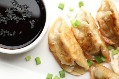 Kızarmış gyoza köftesi, yeşil soğanlı ve soya soslu, yakın plan.