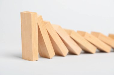Domino etkisi. Tahta bloklar arka planda düşüyor, yakın plan