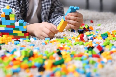 Şirin çocuk evdeki yapı taşlarıyla oynuyor, yakın plan.