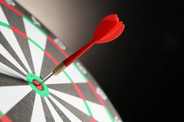 Kırmızı ok hedef tahtasını siyah arkaplana vuruyor. Yakın plan.