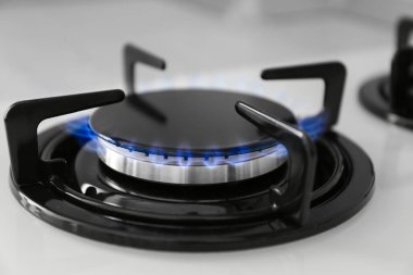 Modern sobanın gaz ocağı, yanan mavi alev, yakın çekim.