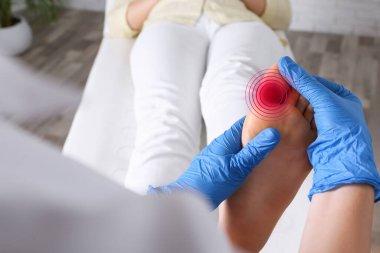 Eklem iltihabı. Doktor hastanede kadının ayağını kontrol ediyor, yakın plan.