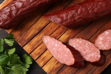 Lezzetli ince tütsülenmiş sosis ve maydanoz masanın üstünde, üst tarafta.