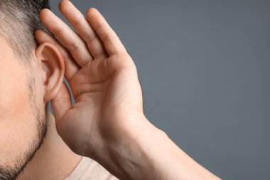 Gri arka planda yumruk yumruğa hareket eden adam, yakın plan.