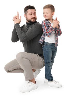 Babası ve küçük tatlı oğlu beyaz arka planda parmak tabancası hareketi yapıyor.