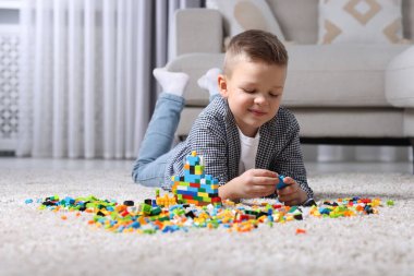 Evdeki yapı taşlarıyla oynayan sevimli çocuk.