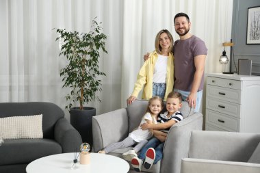 Mutlu ebeveynler ve çocukları evdeki koltukta