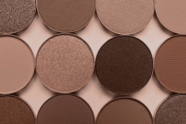 Koyu bej arka planda moka köpüklü gözkapakları, düz bir döşeme. 2025 yılının moda rengi