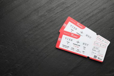 Seyahat acentesi. Uçuş biletleri koyu dokulu masa, üst manzara. Metin için boşluk