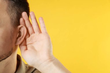 Turuncu arka planda yumruk yumruğa hareket eden bir adam, yakın plan. Metin için boşluk