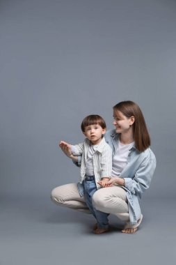 Küçük oğlu gri arka planda mutlu bir anne. Metin için boşluk
