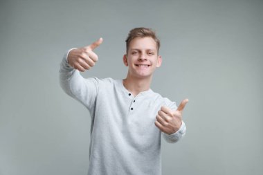 Gri arka planda mutlu bir adam var. Jest gibi