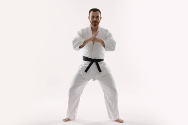 Beyaz arka planda üniformalı bir karateci.