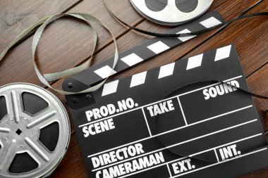 Film alkışı ve film makaraları ahşap masada, düz yatıyordu.