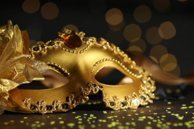 Güzel bir karnaval maskesi ve koyu arkaplanda bulanık ışıkları olan konfeti, yakın plan.