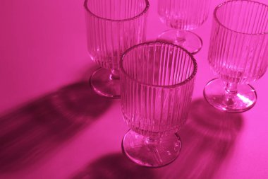 Pembe arka planda boş bardaklar, yakın plan. Renk tonu etkisi
