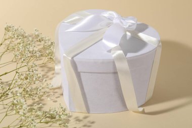 Güzel bir düğün hediyesi ve bej arka planda çingene çiçekleri, yakın plan.