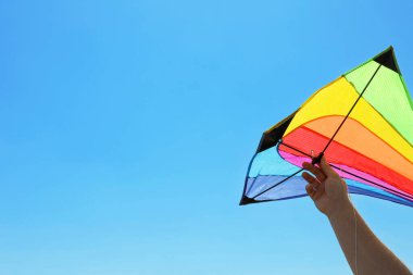 Parlak uçurtmalı adam mavi gökyüzüne karşı, yakın çekim. Metin için boşluk