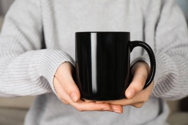Siyah seramik bardaklı kadın, yakın plan. Tasarım için model