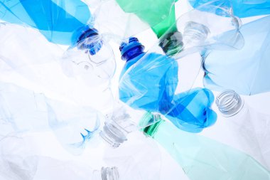 Kırışmış plastik şişeler beyaz arka planda, yakın plan.