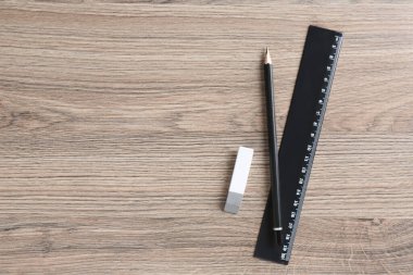 Siyah cetvel, kalem ve silgi ahşap masa, üst manzara. Metin için boşluk
