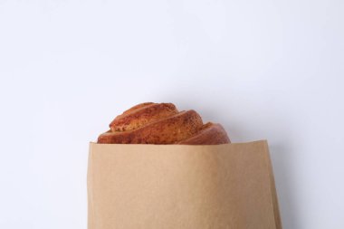 Beyaz arka planda taze pişmiş ekmeği olan kağıt torba, üst manzara.